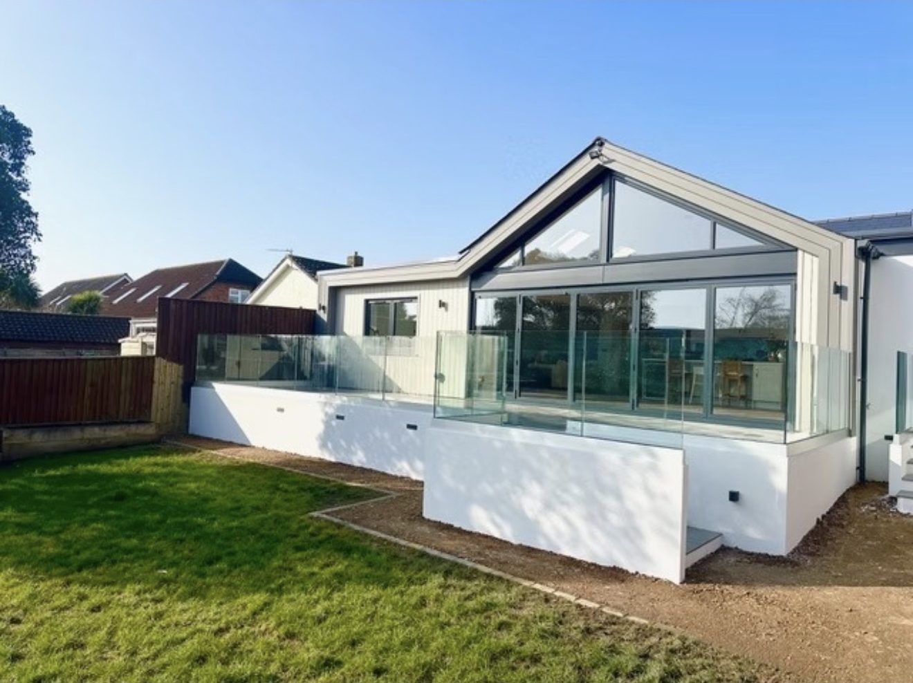Modern house extensions Southampton featuring glass folding doors and patio.